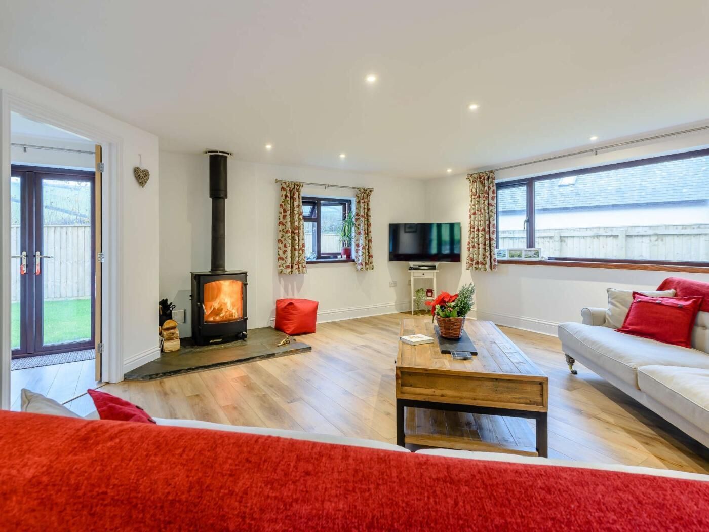 A living room with a fireplace, a sofa, a TV, and a window.