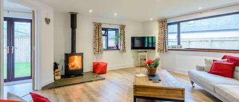 A living room with a fireplace, a sofa, a TV, and a window.