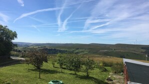 A rural landscape with wind turbines in the distance, a clear sky, and a grassy field with a few trees. - 3 Bed in Todmorden (oc-82953) (Todmorden)