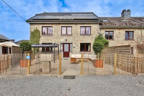 A stone building with a central entrance, a covered seating area, and a gravel driveway. - L'Ecureuil Vacation Rental - Maisons Paladins (Malmedy)