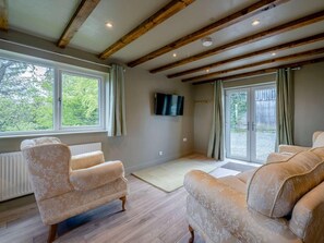 A spacious living room with a high ceiling, wooden beams, a large window, and two sofas. - 2 Bed in Lancaster (oc-82857) (Bentham)