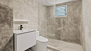 A bathroom with a shower, toilet, and sink. - Barrio Sanctuary - Bosque Azul (San Juan)