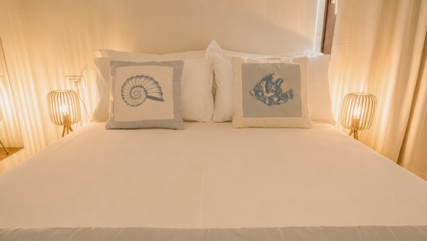 En seng med to puder, hver med et forskelligt design.