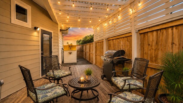 A covered patio with string lights, a grill, and outdoor furniture. - Pet Friendly Retreat - Outdoor Living - Sleeps 9 - Sunset Patios (Port Aransas)