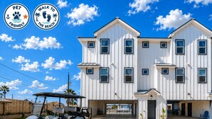 Un bâtiment à deux étages, à l’extérieur blanc, doté de nombreuses fenêtres et d’une entrée fermée par un portail.