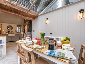 A dining area with a wooden table, chairs, a coffee maker, and a bowl of fruit. - 3 Bed in Belper (oc-83037) (Blackbrook)
