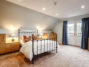 A bedroom with a bed, bedside tables, a nightstand, a window with curtains, and a ceiling light. - 4 Bed in Helmsdale (oc-83074) (Helmsdale)