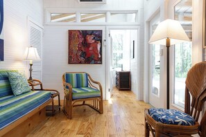 A room with a wooden floor, a sofa, a chair, a lamp, and a painting. - One-of-a-Kind Artist Retreat, 4Min Walk to Beach (Corolla)