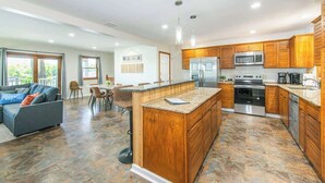 Una cucina moderna con mobili in legno, elettrodomestici in acciaio inossidabile e un'isola centrale.