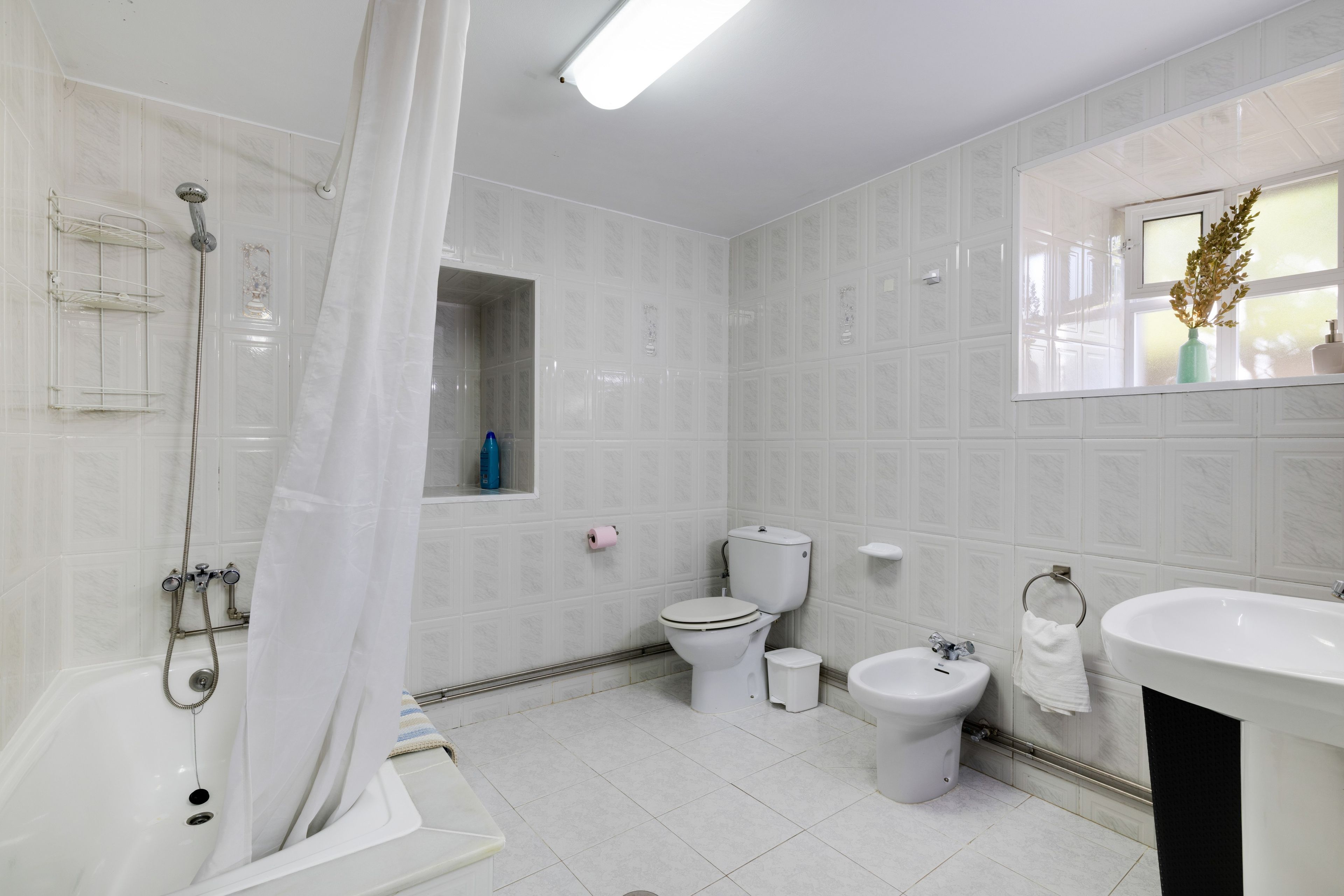 Une salle de bain moderne équipée d’une douche, de toilettes, d’un bidet et d’un lavabo.