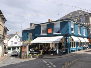 A blue building with a cafe named 'The Cosy Cafe' on the ground floor.
