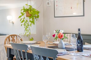 Une table à manger dressée avec des assiettes, des verres et une bouteille de vin.