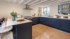 A modern kitchen with a central island, dark cabinetry, and a window providing natural light.
