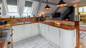 A modern kitchen with a central island, a built-in oven, and pendant lighting. - 2 Bed in Morpeth (oc-83597) (Rothbury)