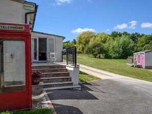 A mobile home with a porch, a telephone booth, and a gravel driveway. - 2 Bed in Taunton (oc-83696) (Thornfalcon)
