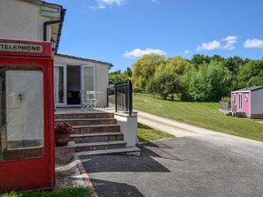 A mobile home with a porch, a telephone booth, and a gravel driveway. - 2 Bed in Taunton (oc-83696) (Thornfalcon)