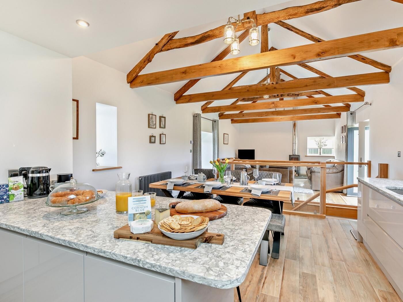 Una cucina moderna con piani in marmo, travi in legno e zona pranzo con vista.