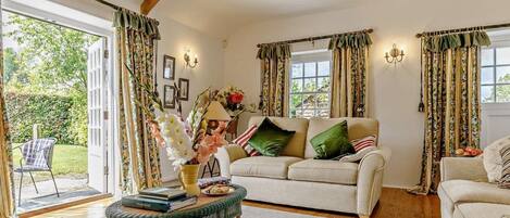 A cozy living room with a sofa, a coffee table, and curtains.