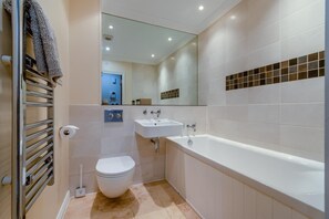 A modern bathroom with a toilet, sink, and bathtub. - 3 Bed in Swanage (oc-83794) (Swanage)