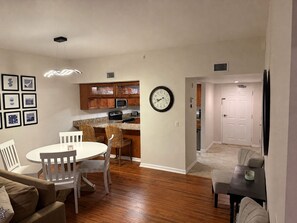 A modern kitchen with wooden cabinets, a microwave, and a clock on the wall. - Casa Marina Condo with amenities (Fort Myers Beach)