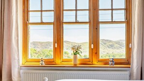 Une chambre avec une grande fenêtre, un radiateur et un lit.