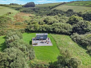 A modern house with a patio, surrounded by lush greenery and hills. - 1 Bed in Boscastle (oc-84015) (Forrabury and Minster)