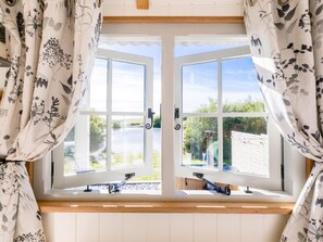 A room with a large window, curtains, and a view of greenery outside. - 1 Bed in Boscastle (oc-84015) (Forrabury and Minster)