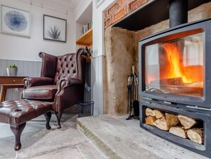 Ein gemütliches Wohnzimmer mit Kamin, Ledersessel und Essbereich.