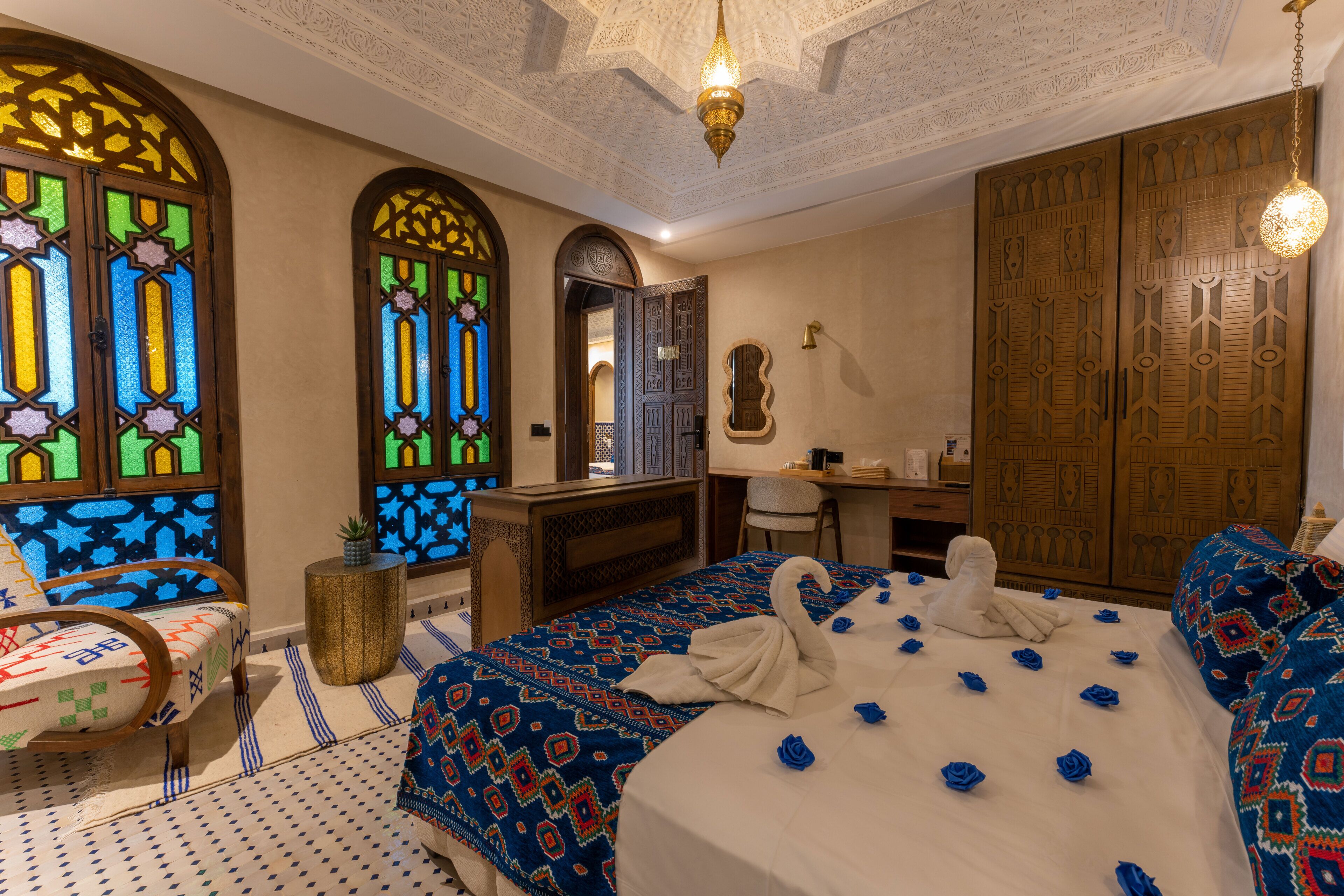 Una habitación con cama, escritorio, silla y espejo.