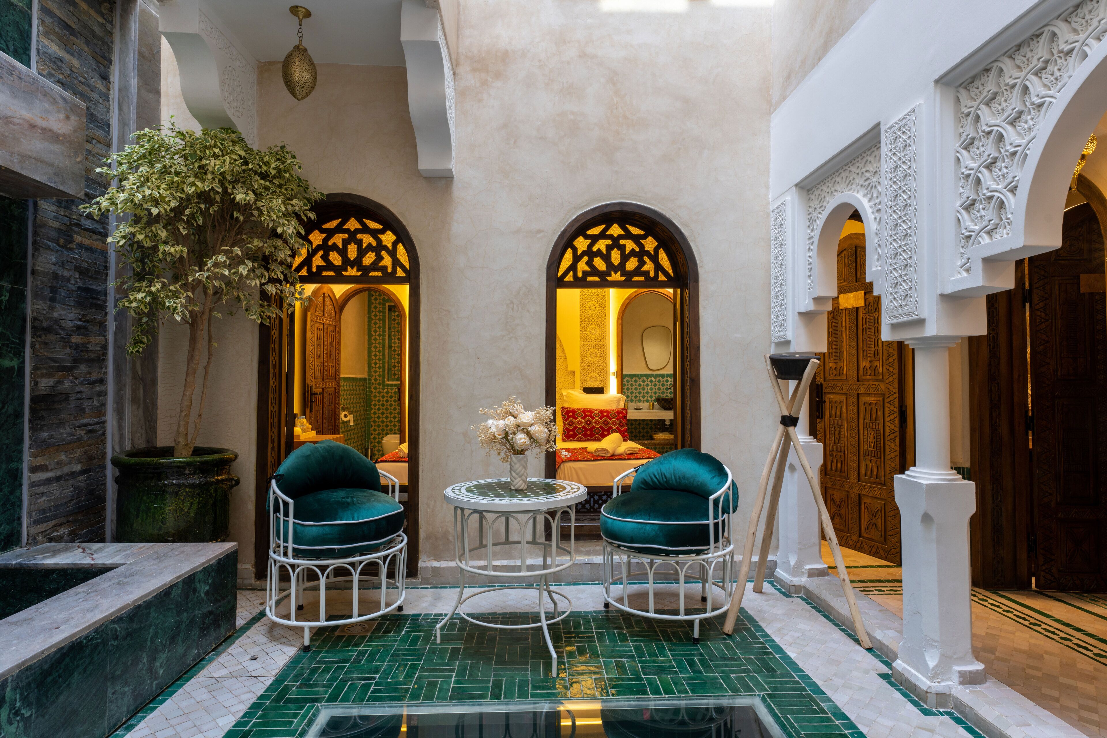 A traditional interior with a fountain, two chairs, and a table.