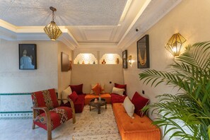 A traditional interior with a sofa, chairs, and a patterned rug. - Riad Secret Mahjouba (Marrakech)