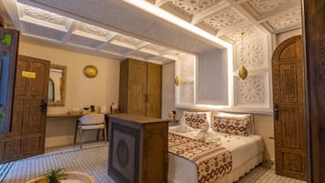Una habitación tradicional con cama, escritorio y silla.