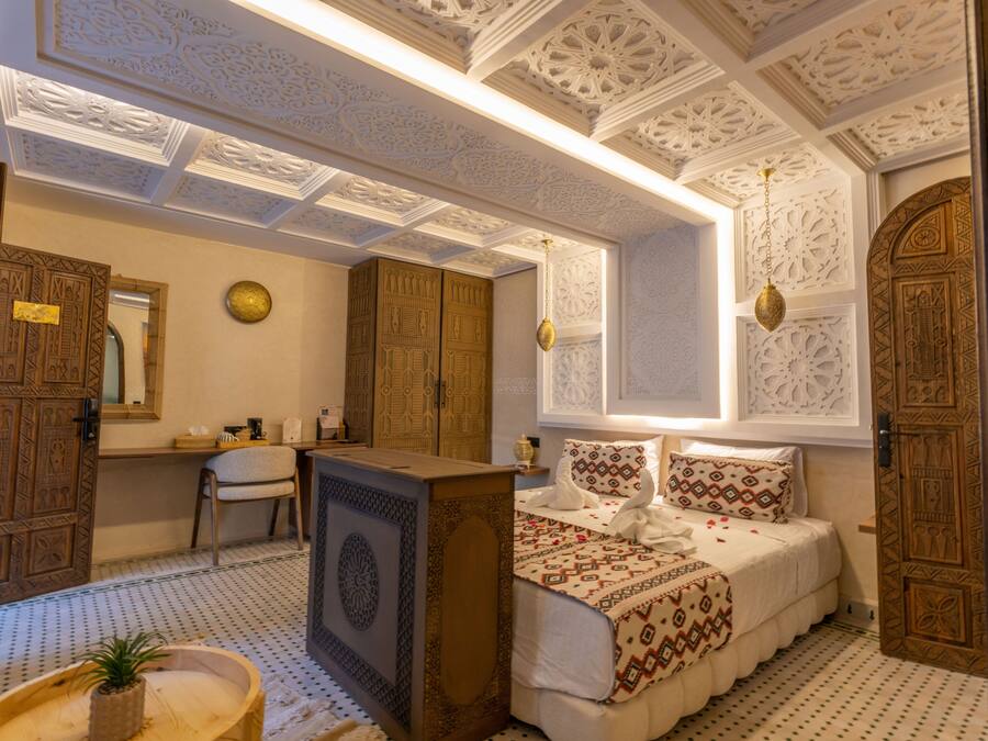 Una habitación tradicional con cama, escritorio y silla.