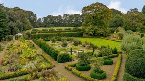 A meticulously landscaped garden with various plant beds, a central lawn, and a curved pathway. - 5 Bed in Harrogate (oc-83892) (Markington)