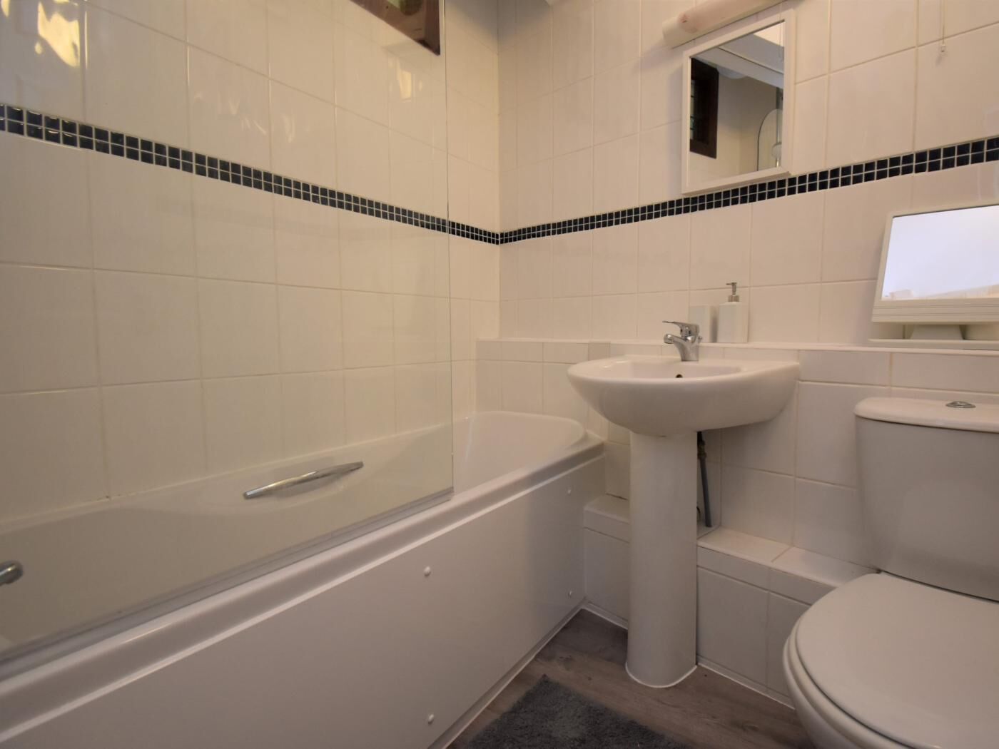 A bathroom with a bathtub, sink, and toilet.