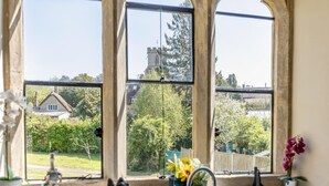 Una ventana con vistas a una casa y árboles.
