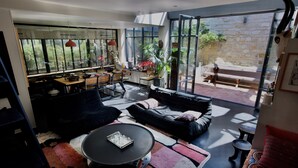 En moderne stue med sofa, sofabord og spiseplads.