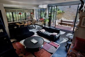 Ein modernes Wohnzimmer mit Sofa, Couchtisch und Essbereich.