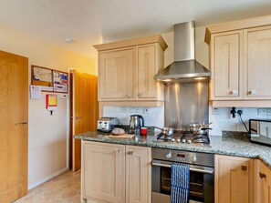 A modern kitchen with wooden cabinets, stainless steel appliances, and a granite countertop. - 2 Bed in Keswick (oc-sz008) (Keswick)
