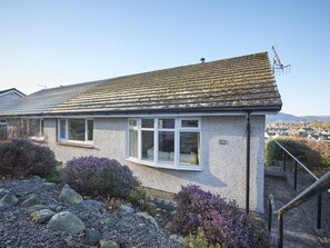 A single-story house with a sloped roof, a small porch, and a staircase leading to the entrance. - 2 Bed in Keswick (oc-sz008) (Keswick)