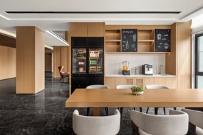 A modern kitchen with a built-in refrigerator, coffee machine, and a chalkboard menu.