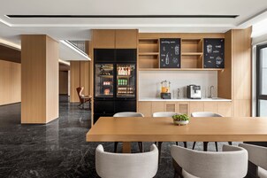 Una cocina moderna con refrigerador empotrado, máquina de café y menú en una pizarra.
