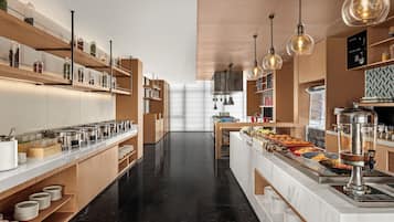 Una cocina moderna con barra tipo bufé, electrodomésticos de acero inoxidable y estanterías de madera.