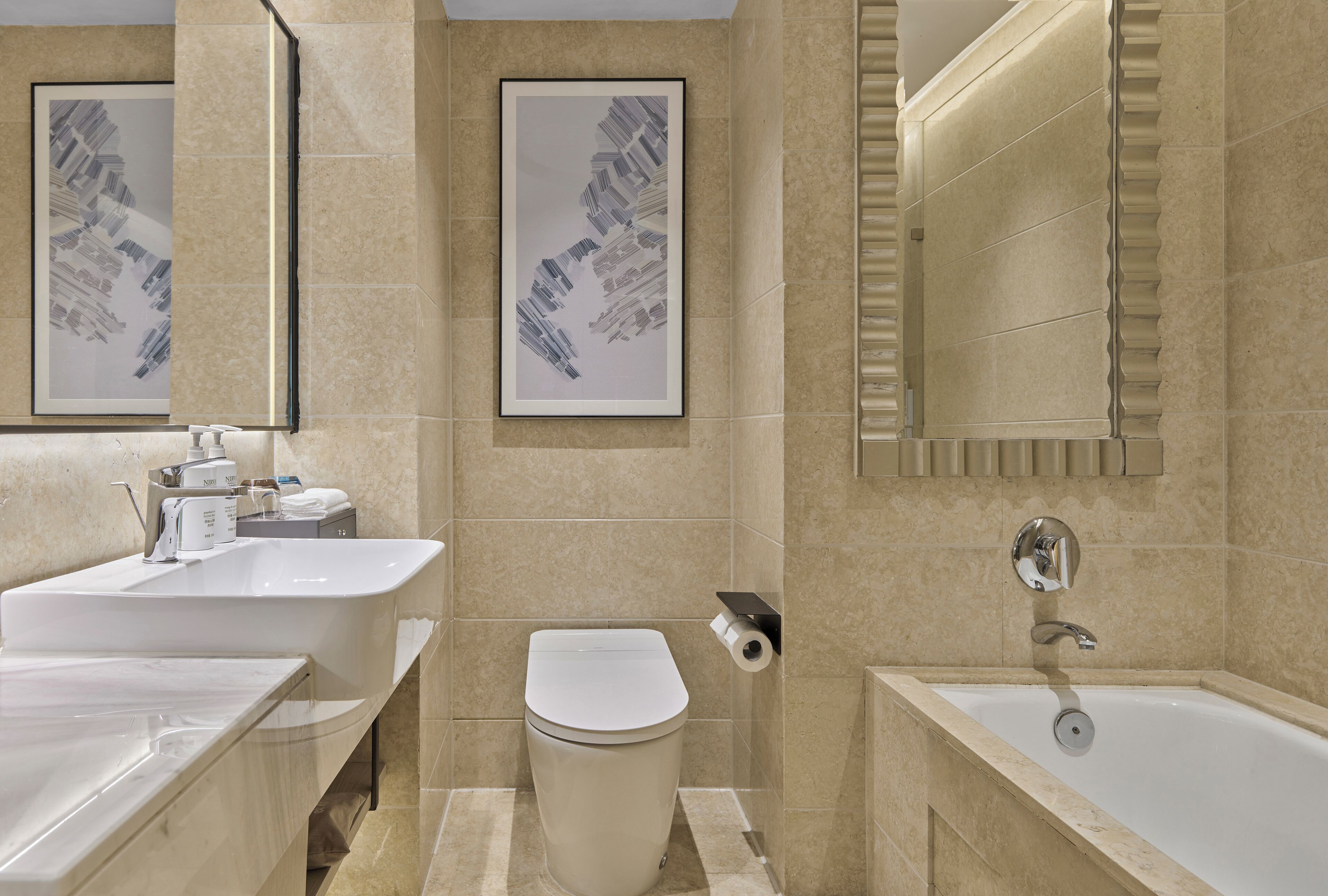 Un baño moderno con dos lavamanos, un inodoro y una bañera.