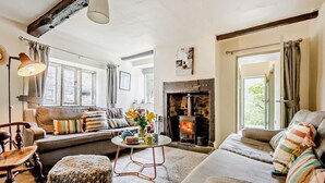 A cozy living room with a fireplace, a sofa, a coffee table, and a lamp. - 4 Bed in Buttermere (oc-sz090) (Buttermere)