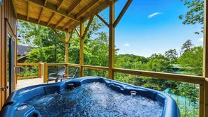 A hot tub under a wooden deck with a view of a forest. - New Build Cabin! Close to Mountains, Dollywood, Parkway, Pigeon Forge (Pigeon Forge)