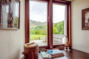 A room with a large window offering a view of a green landscape and hills. - 3 Bed in Borrowdale (oc-sz465) (Borrowdale)