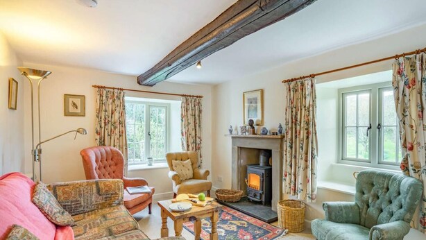 A cozy living room with a fireplace, floral curtains, and traditional furniture. - 3 Bed in Cumbria (oc-sz101) (Crosthwaite and Lyth)