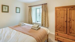 A bedroom with a bed, a window with curtains, a wardrobe, and two framed botanical prints on the wall. - 3 Bed in Cumbria (oc-sz101) (Crosthwaite and Lyth)
