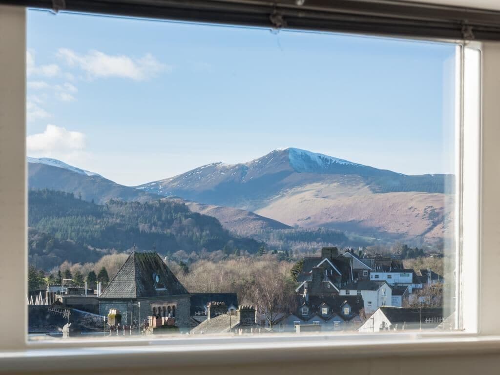A view of a town with buildings and a mountain in the background.